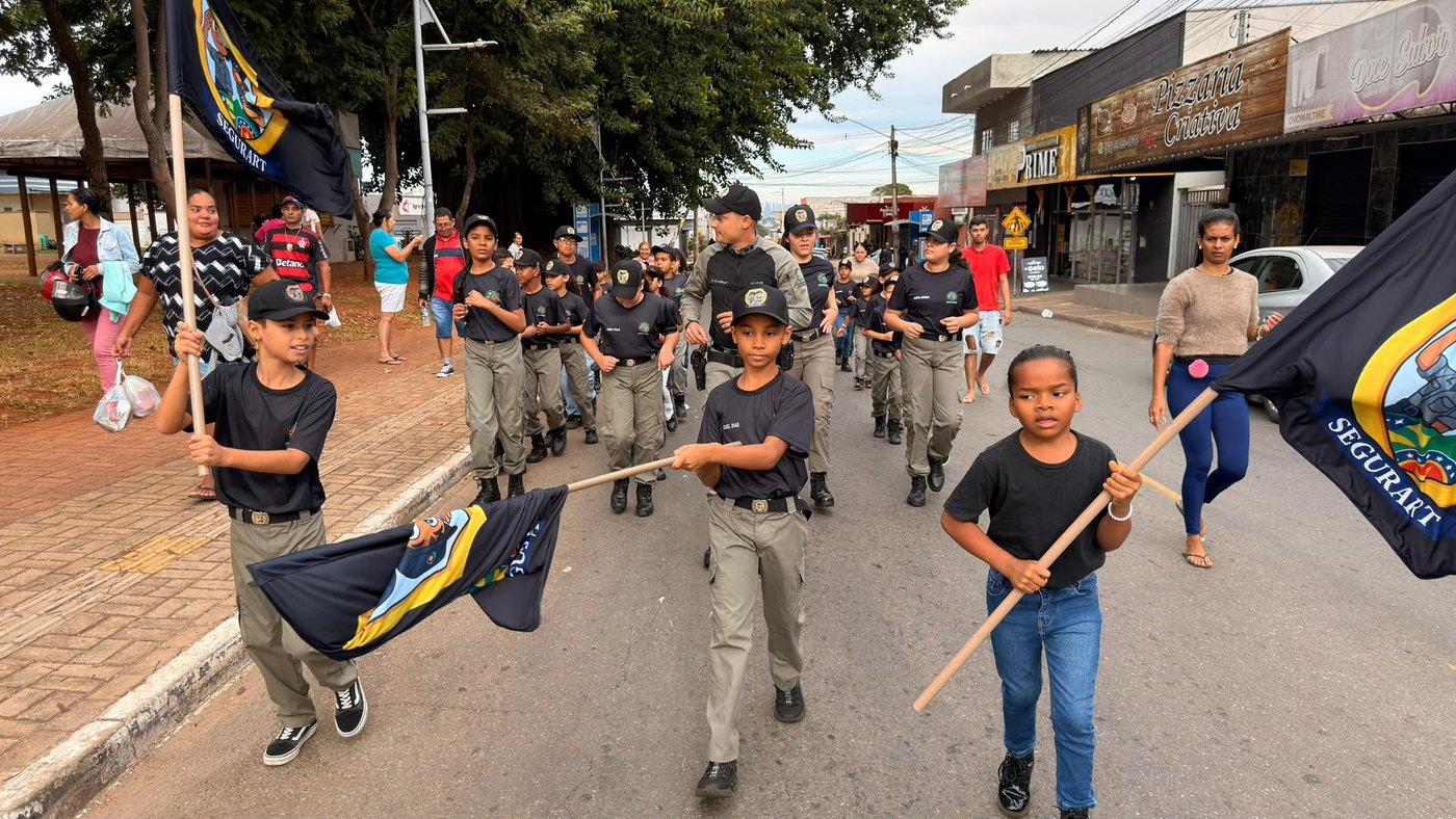 Crianças do Segurart no desfile, carregando a bandeira do programa