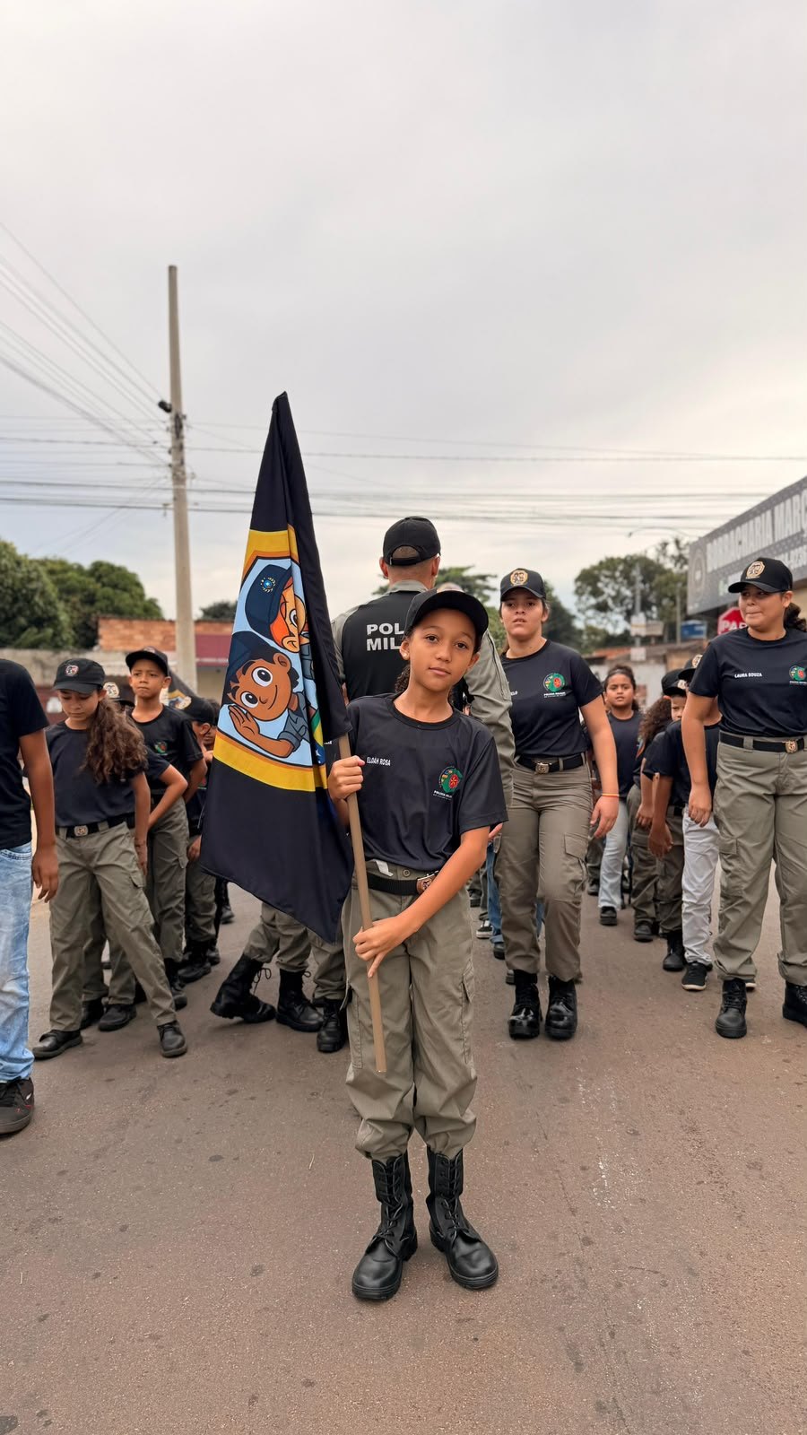 Aluno do Segurart à frente da formação, carregando a bandeira do programa